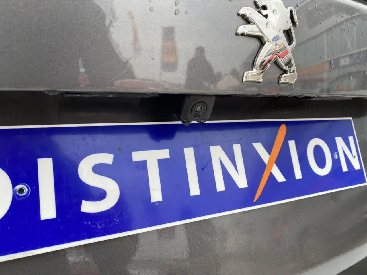 Gros plan sur l'arrière gris foncé du Peugeot 2008 avec logo lion et caméra de recul au-dessus de la plaque Distinxion.