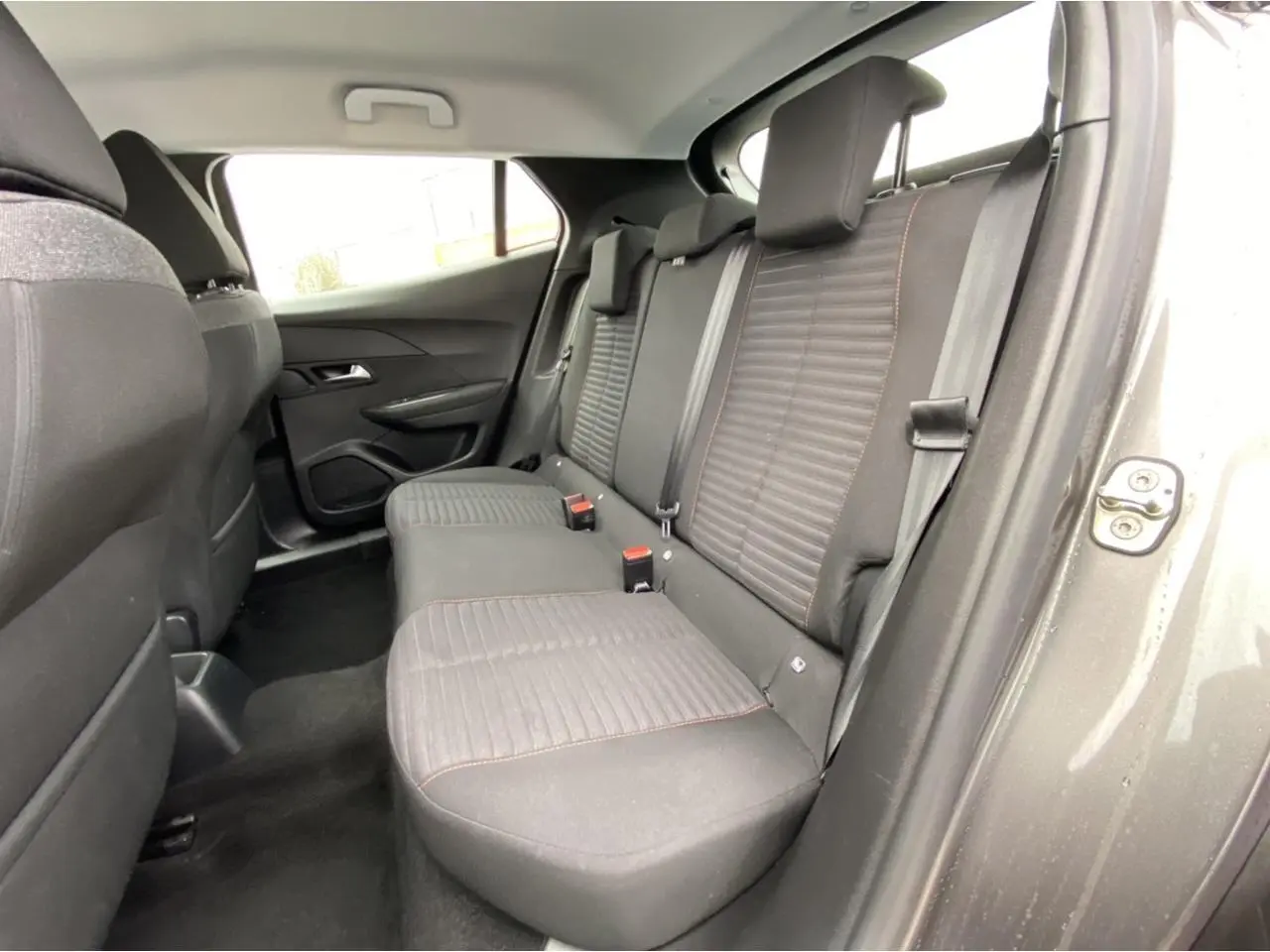 Vue intérieure arrière droite des sièges noirs avec surpiqûres rouges du Peugeot 2008 gris foncé 2021 Active Pack
