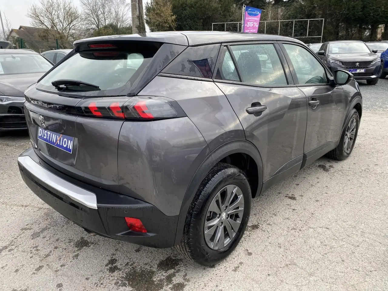 Peugeot 2008 gris foncé vue 3/4 arrière droit, feux arrière LED 3 griffes et jantes alliage visibles.