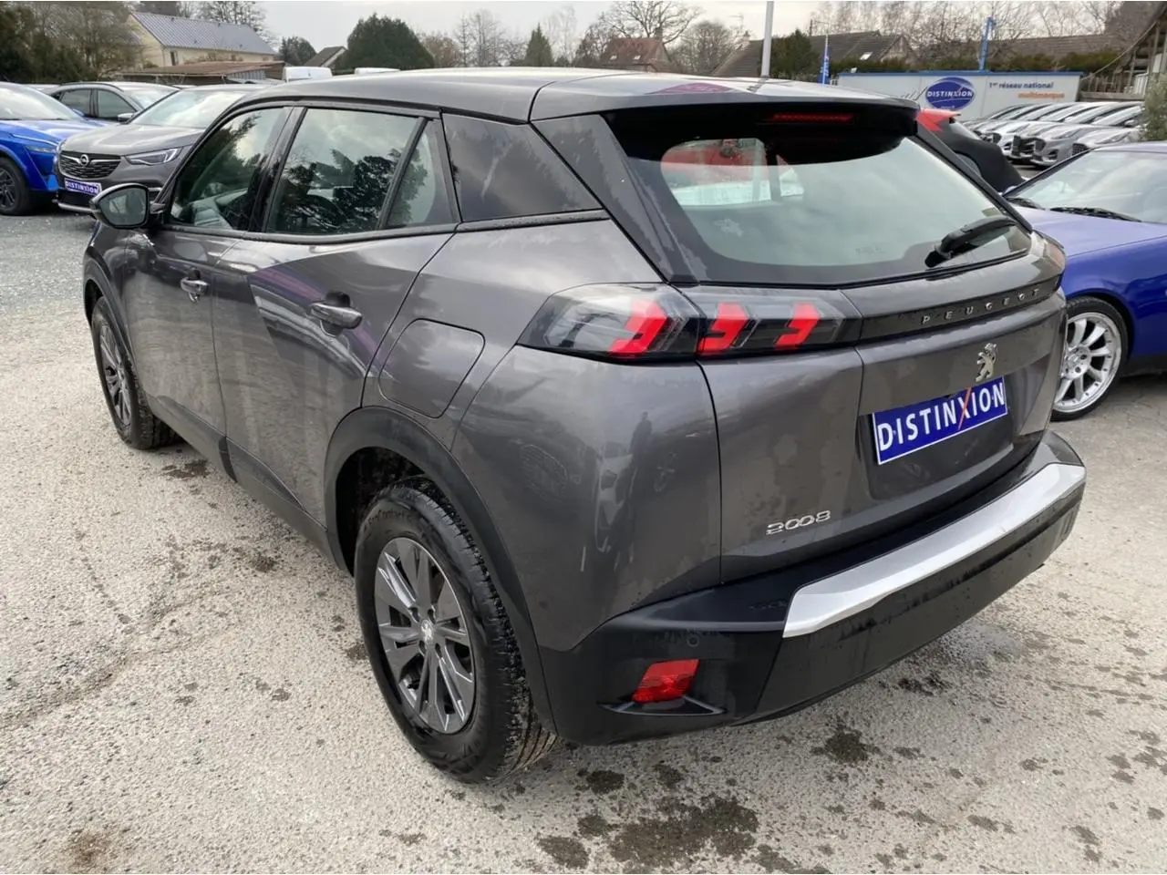 Peugeot 2008 gris foncé vue 3/4 arrière droit, feux arrière LED à trois griffes et toit noir contrasté.