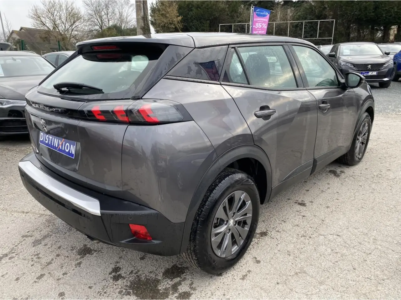 Peugeot 2008 gris foncé en 3/4 arrière droit, mettant en valeur ses feux arrière LED à trois griffes distinctifs.