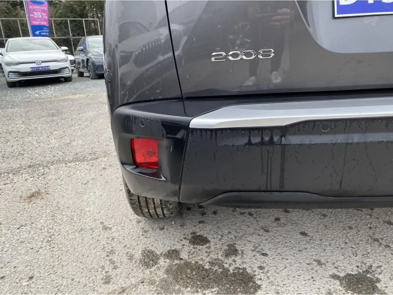 Gros plan sur le coin arrière gauche d'un Peugeot 2008 gris foncé montrant le feu arrière rouge et le logo 2008.
