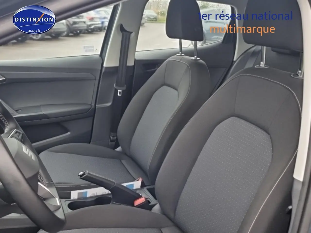 Vue intérieure côté gauche montrant les sièges avant gris tissu de la SEAT Ibiza 2025 avec volant multifonction cuir.