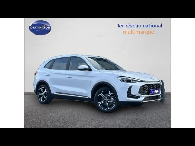 Vue 3/4 avant droit du SUV blanc MG ZS Hybrid+ 197ch Comfort avec jantes alu et calandre noire distinctive.