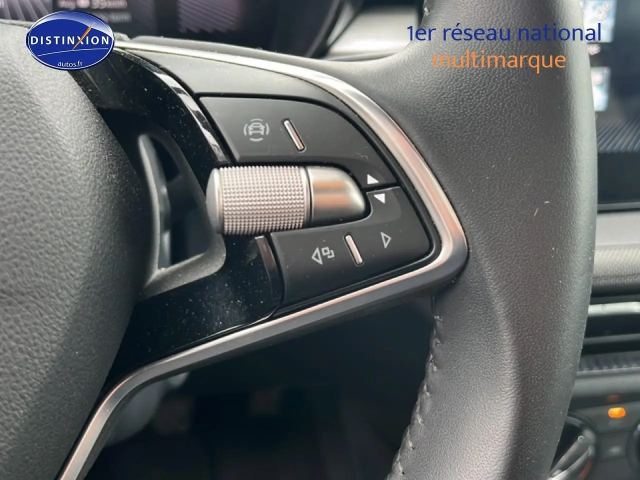 Gros plan sur les commandes gauche du volant cuir multifonction d’une Skoda Fabia blanche 2025.