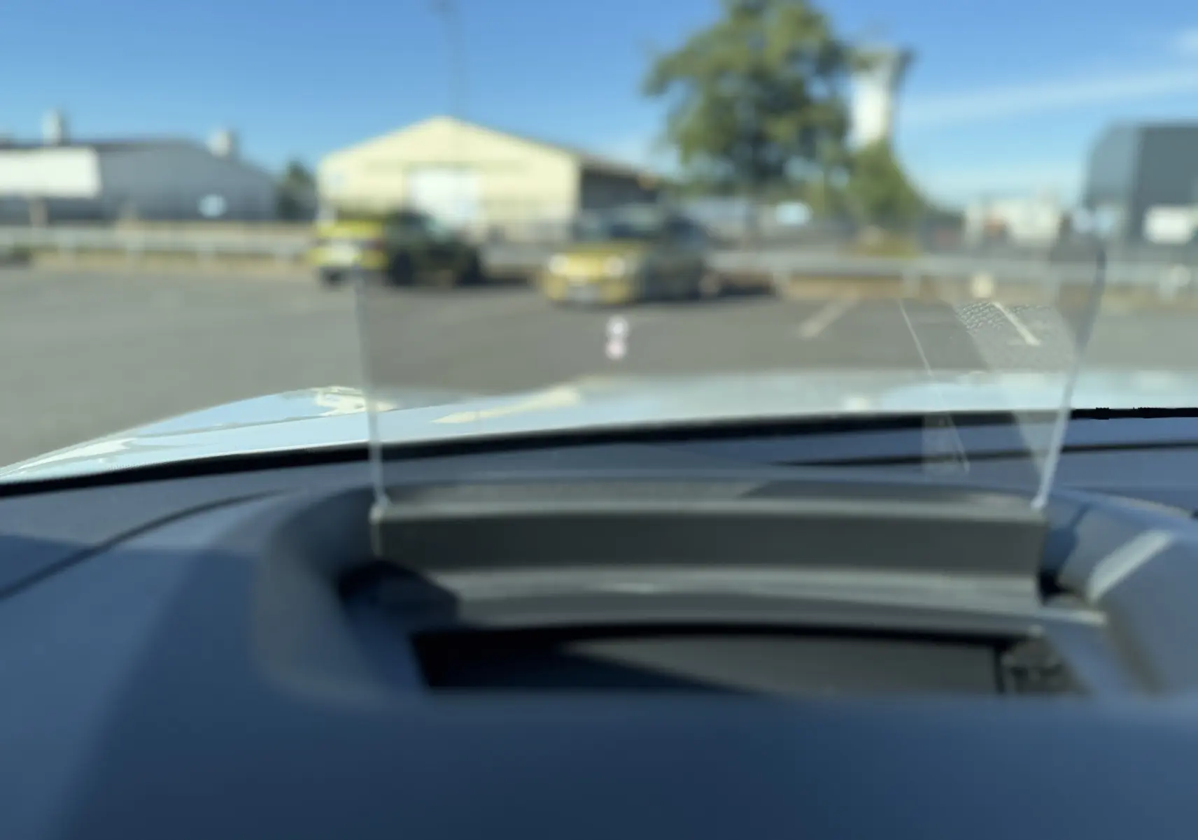 Vue intérieure du tableau de bord de la Citroën C4 hybride blanche, avec affichage tête haute transparent en avant.