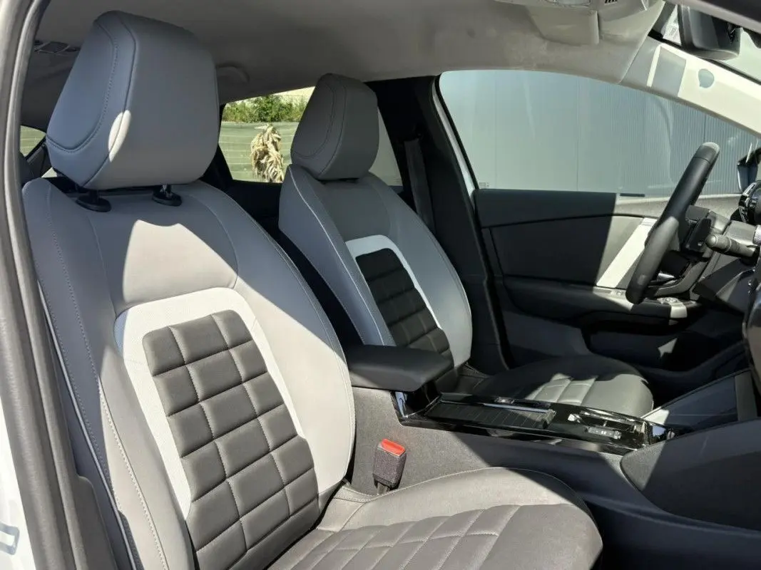 Vue intérieure côté conducteur de la Citroën C4 Hybrid 145 ch 2025 avec sièges bi-ton gris clair et foncé.