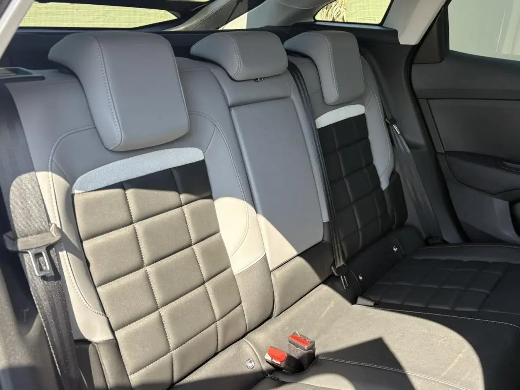 Vue intérieure des sièges arrière en cuir noir et gris de la Citroën C4 Hybrid 2025, avec appuie-têtes et ceintures visibles.