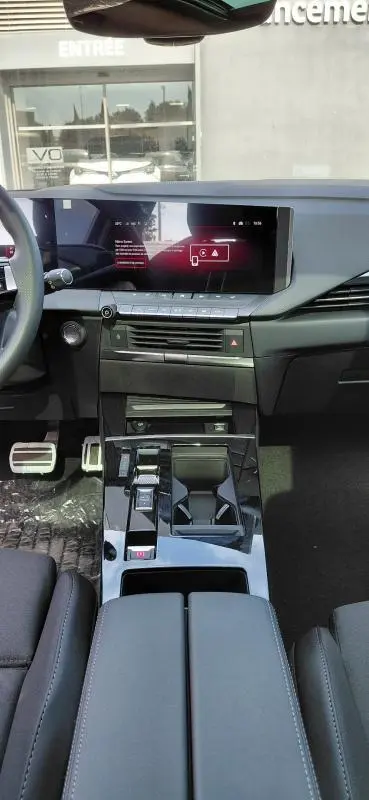 Intérieur avant de l’Opel Astra 2025 noir, vue centrée sur la console avec écran tactile et volant cuir.