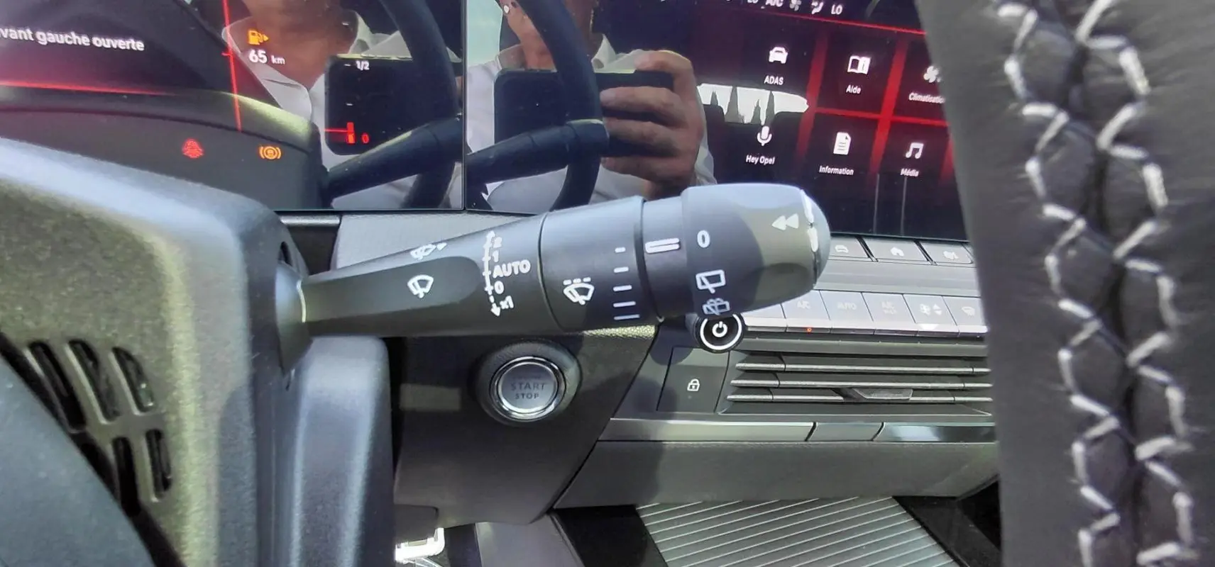 Gros plan sur la commande des essuie-glaces et le tableau de bord numérique de l’Opel Astra noire, version 2025.