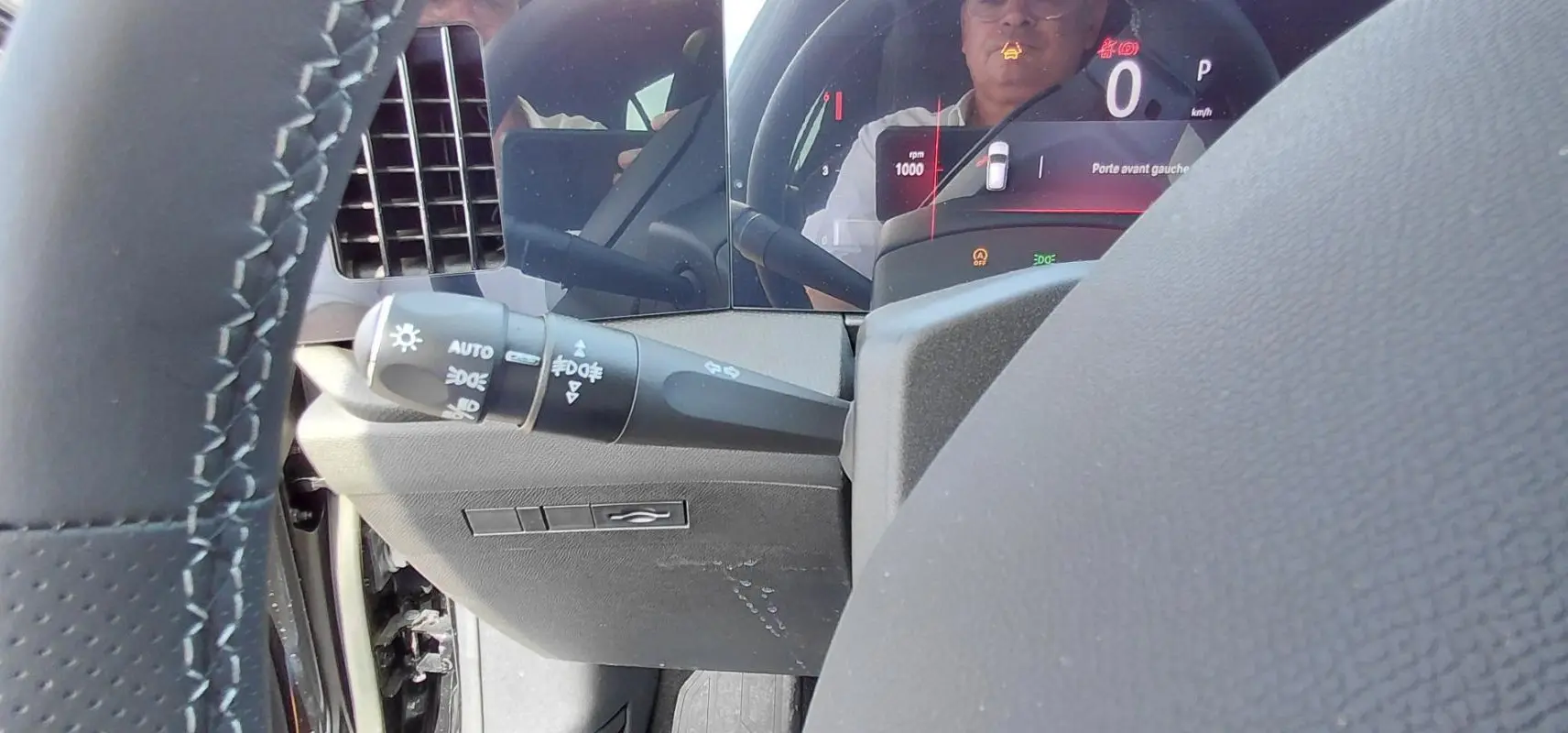 Gros plan sur le volant cuir et le combiné numérique de l’Opel Astra noire, affichant le tableau de bord digital.