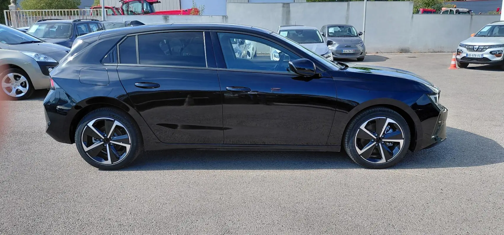 Opel Astra 2025 noire vue de profil côté gauche avec jantes alliage 17 pouces et vitres surteintées.