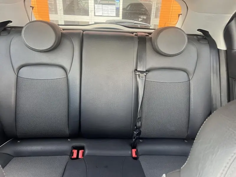Vue rapprochée de la banquette arrière en cuir noir de la Fiat 500X 2015 avec appuie-têtes ronds et ceinture de sécurité.