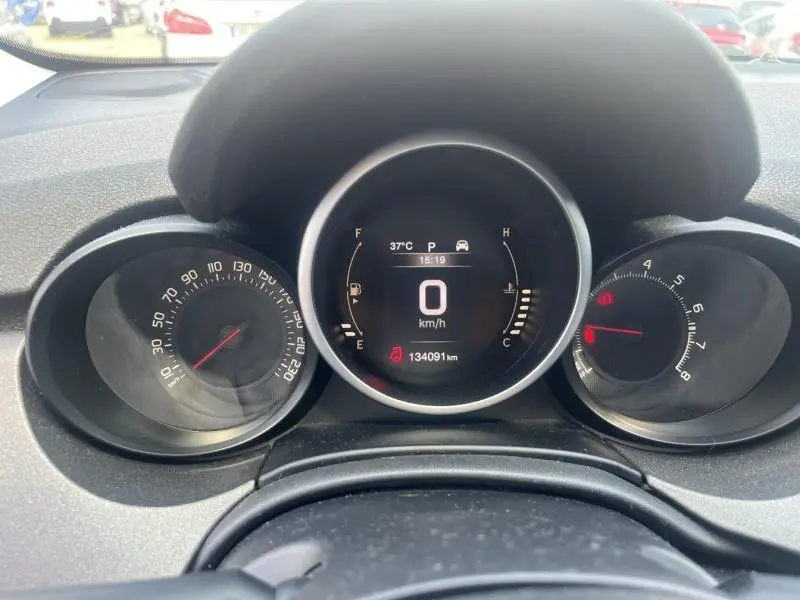Tableau de bord numérique du Fiat 500X 2015 montrant vitesse à 0 km/h et jauges essence et température.