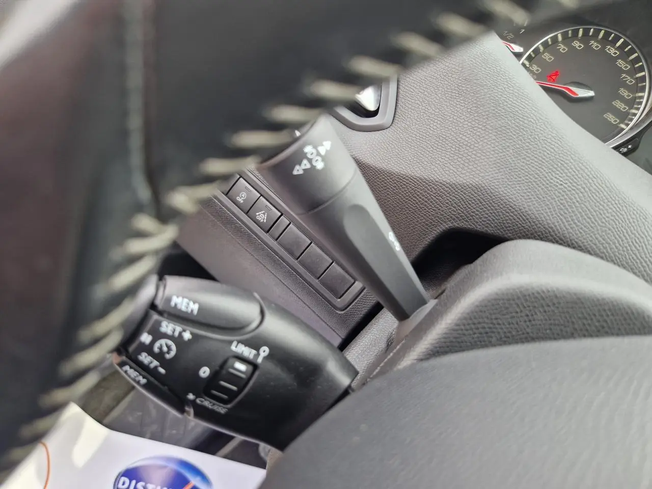 Gros plan sur les commandes de régulateur de vitesse et limiteur, tableau de bord gris intérieur Peugeot 308 2018.