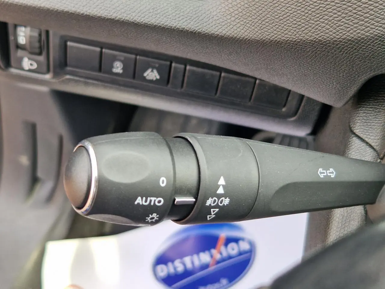 Gros plan sur la commande des phares automatique et clignotants du Peugeot 308 gris Artense, intérieur noir.