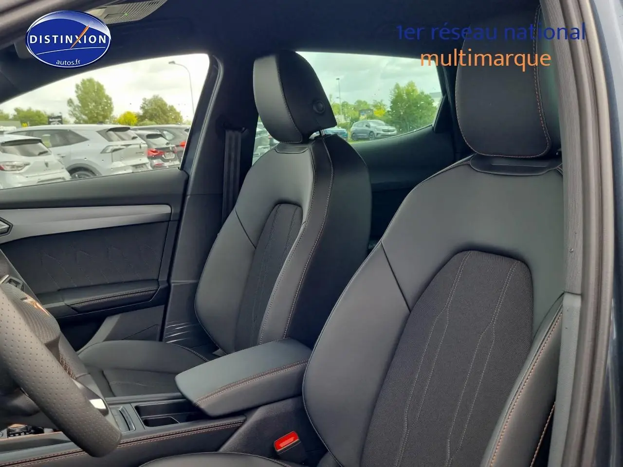 Intérieur avant du CUPRA Formentor 1.5 eTSI hybride 2025, sièges sport noirs avec surpiqûres marron et accoudoir central.