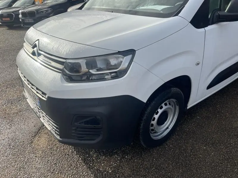 Vue 3/4 avant droit d'un Citroën Berlingo Fourgon blanc Banquise avec pare-chocs noir et jante acier simple.