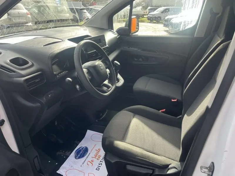 Intérieur avant du Citroën Berlingo Fourgon blanc, sièges tissu gris, tableau de bord avec volant multifonctions.