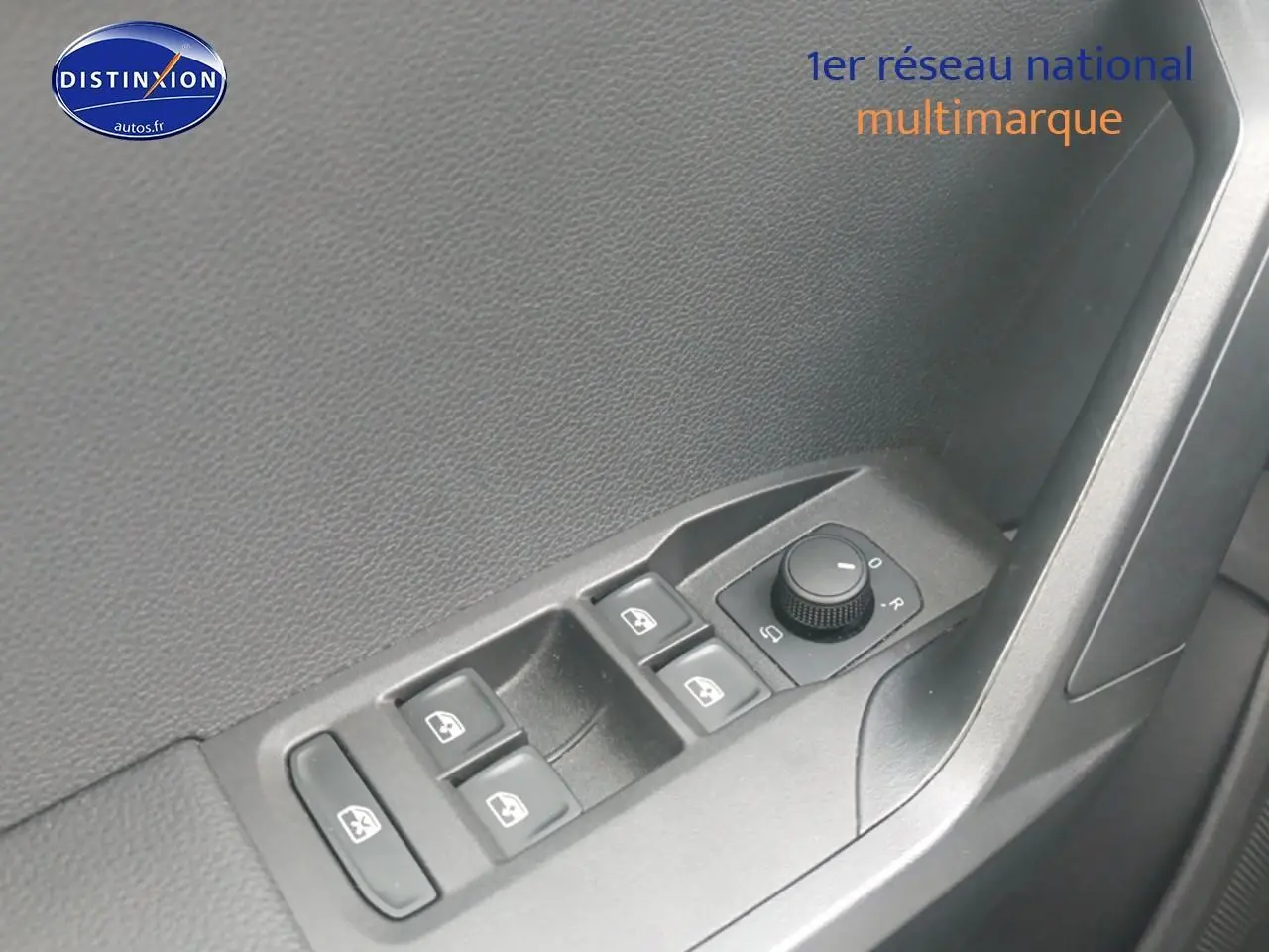 Gros plan sur les commandes de vitres électriques et rétroviseurs côté conducteur d'une SEAT Ibiza blanc Nevada.