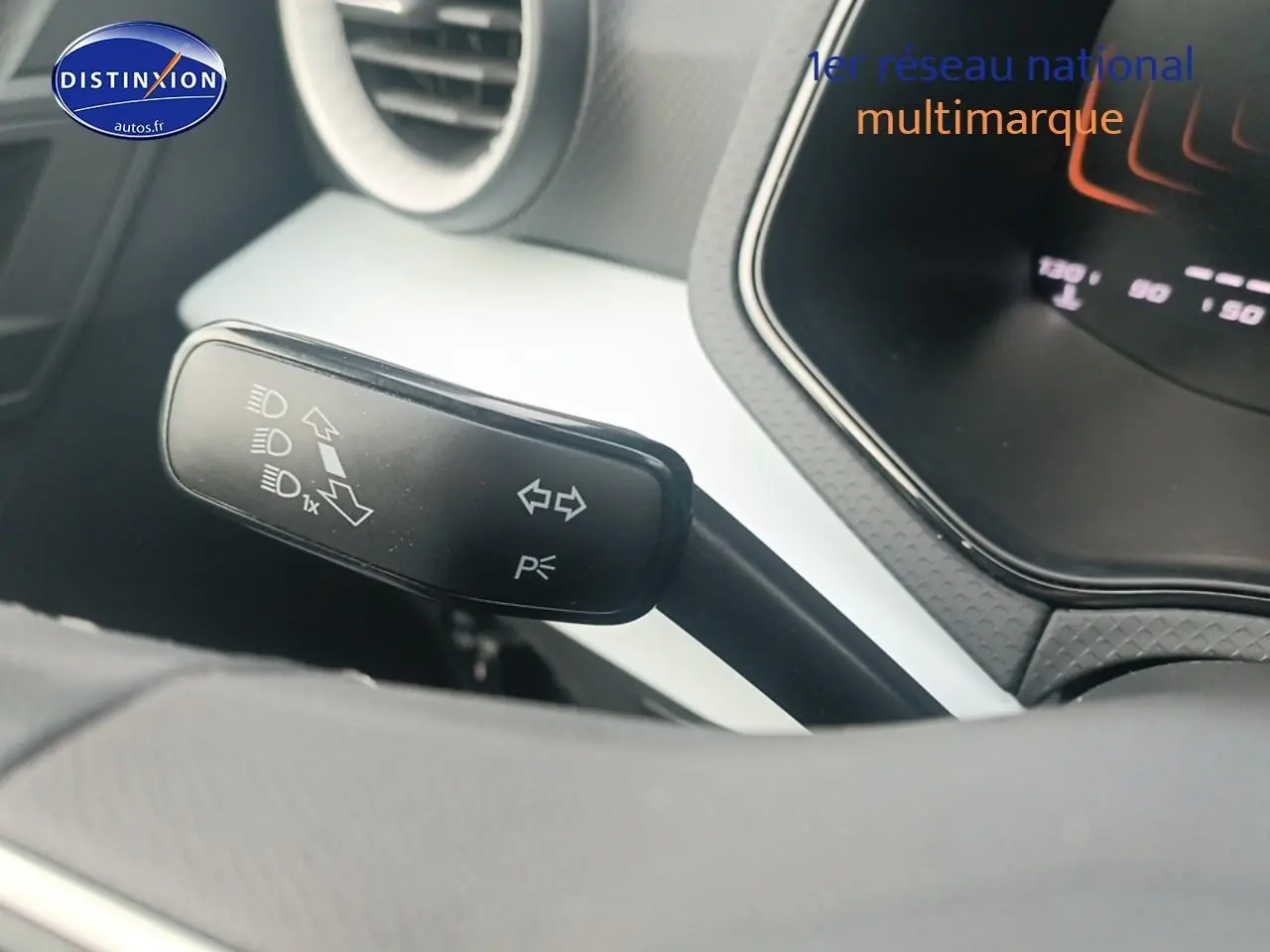 Gros plan sur la manette de clignotant à gauche du volant dans l’habitacle blanc et noir d’une SEAT Ibiza 2025.