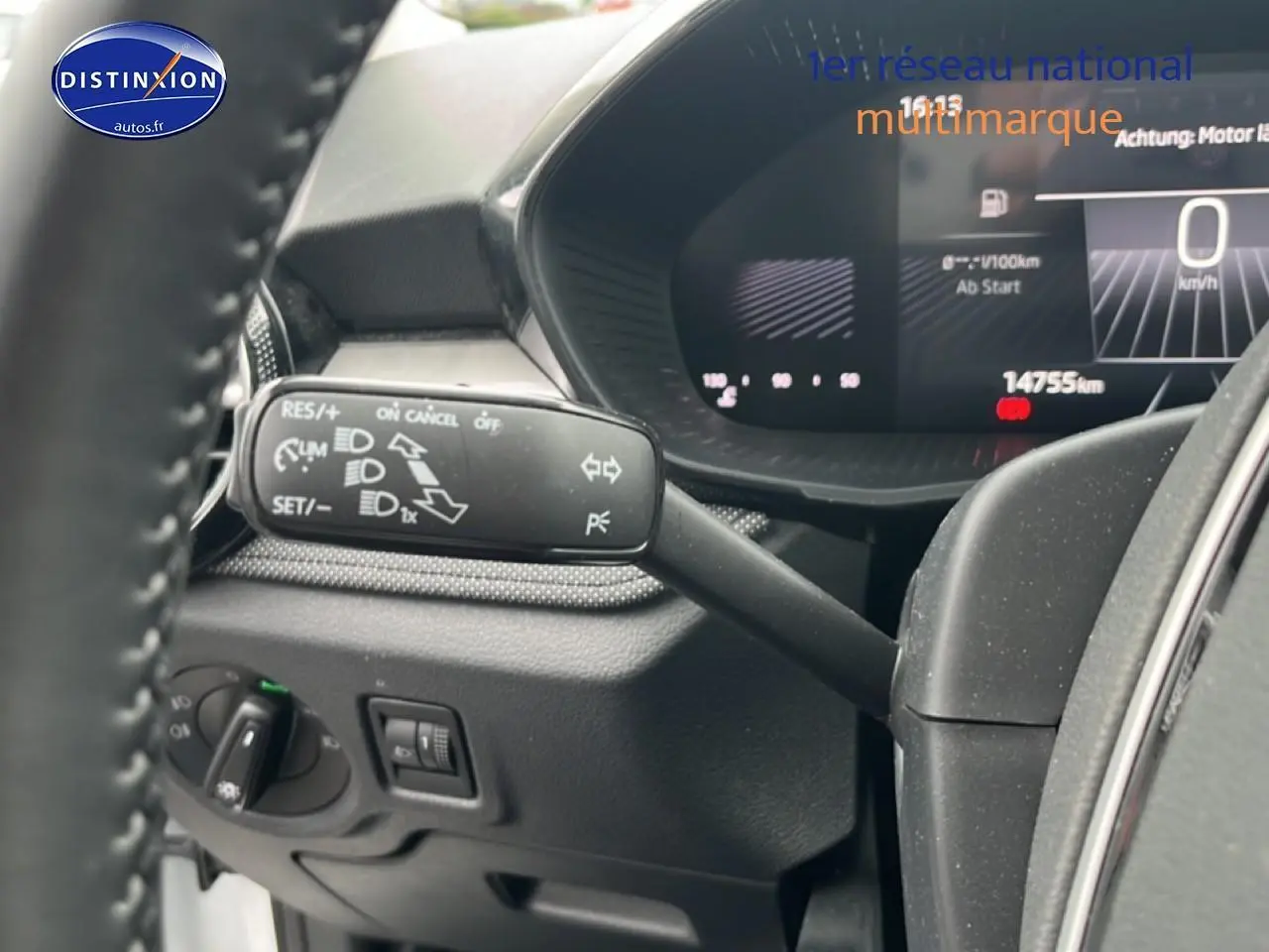Détail du commodo de clignotant et tableau de bord numérique d'une Skoda Fabia blanche, vue intérieure côté conducteur.