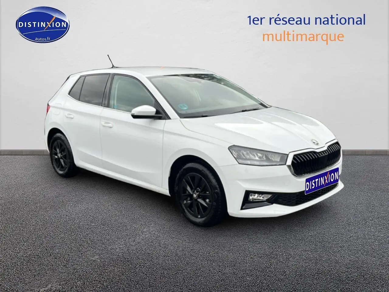 Vue 3/4 avant gauche d'une Skoda Fabia blanche avec jantes noires et calandre noire distinctive.