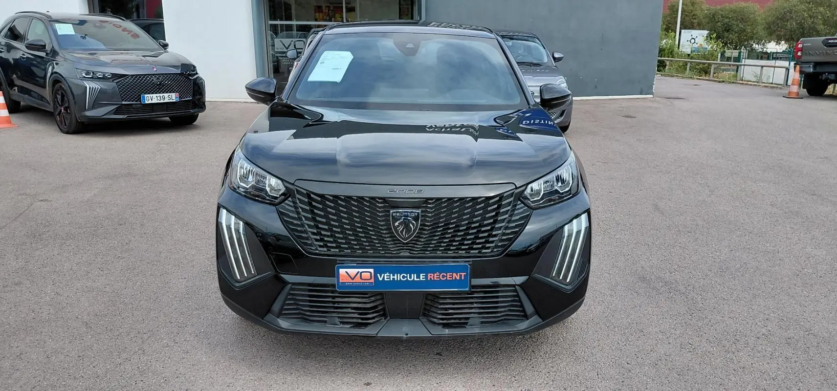 Vue frontale d’un Peugeot 2008 Hybrid 145 e-DCS6 Style noir 2025 avec calandre et feux LED distinctifs.