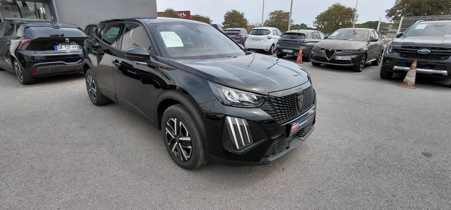 Peugeot 2008 Hybrid 145 Style noir en 3/4 avant droit, avec feux LED distinctifs et jantes modernes.