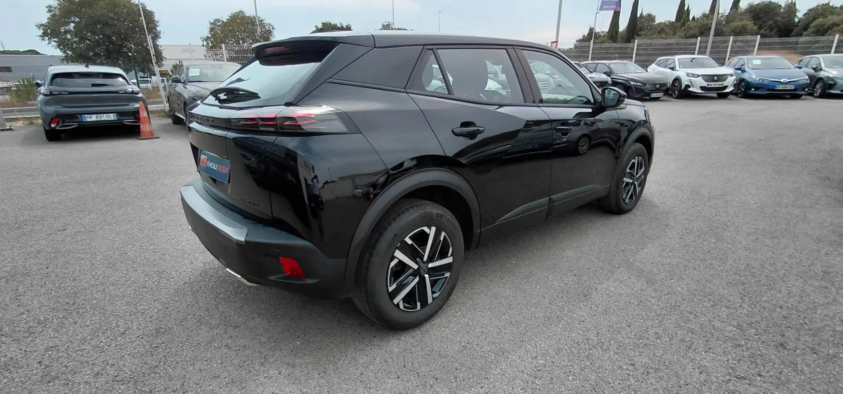 Peugeot 2008 Hybrid 145 noir vue 3/4 arrière droit, avec jantes alliage et feux arrière LED distinctifs.