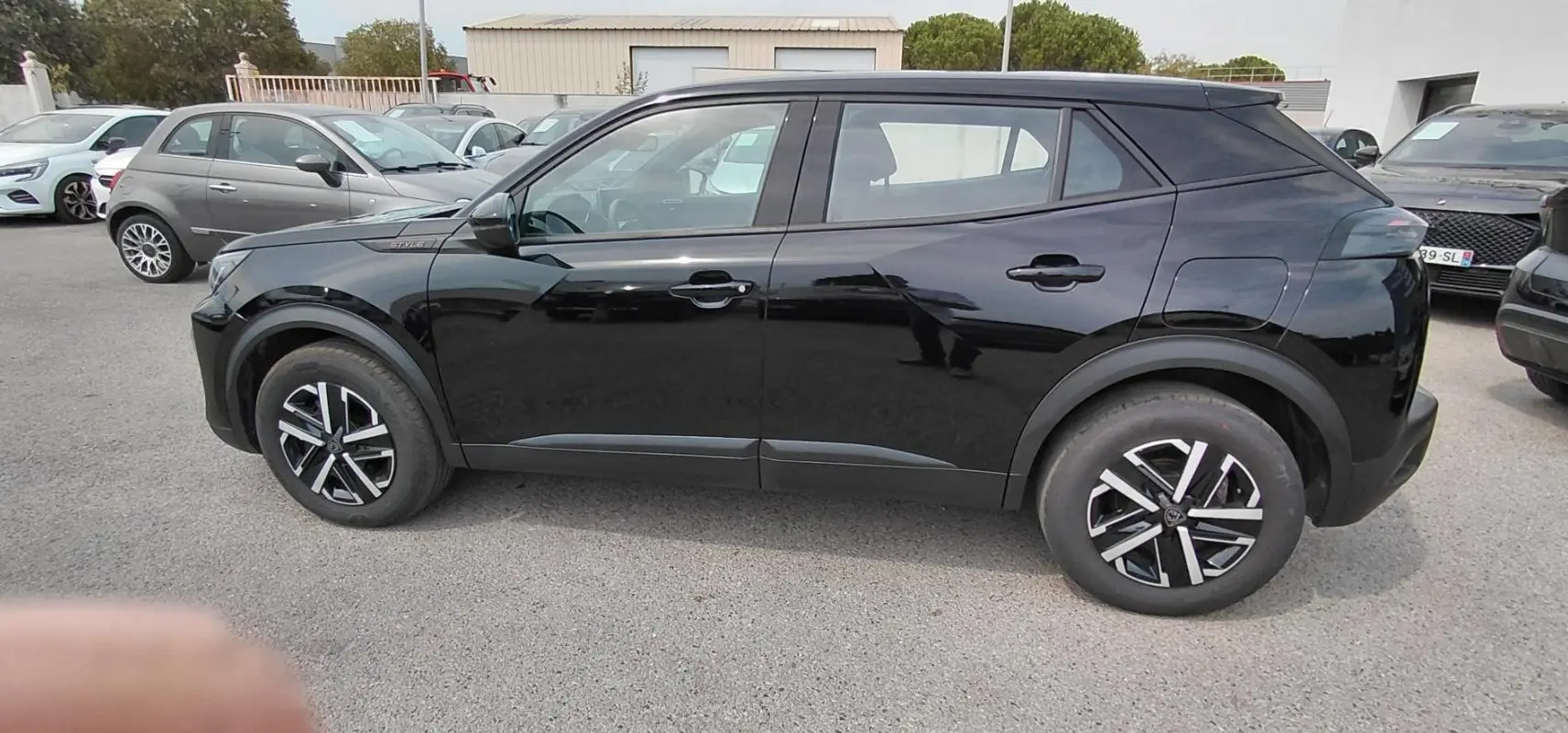 Peugeot 2008 Hybrid 145 e-DCS6 Style noir vu de profil côté gauche, avec jantes alliage distinctives.