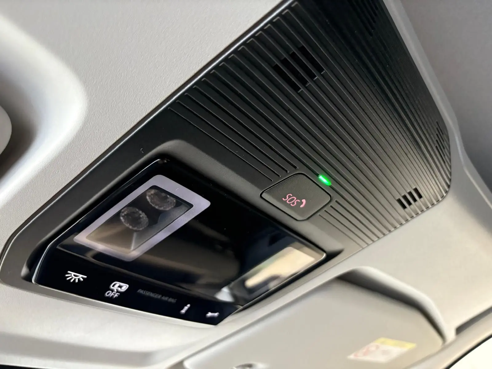 Plafonnier intérieur avec bouton SOS et éclairage, Volkswagen Caddy gris argent 2025, vue en léger contre-plongée.