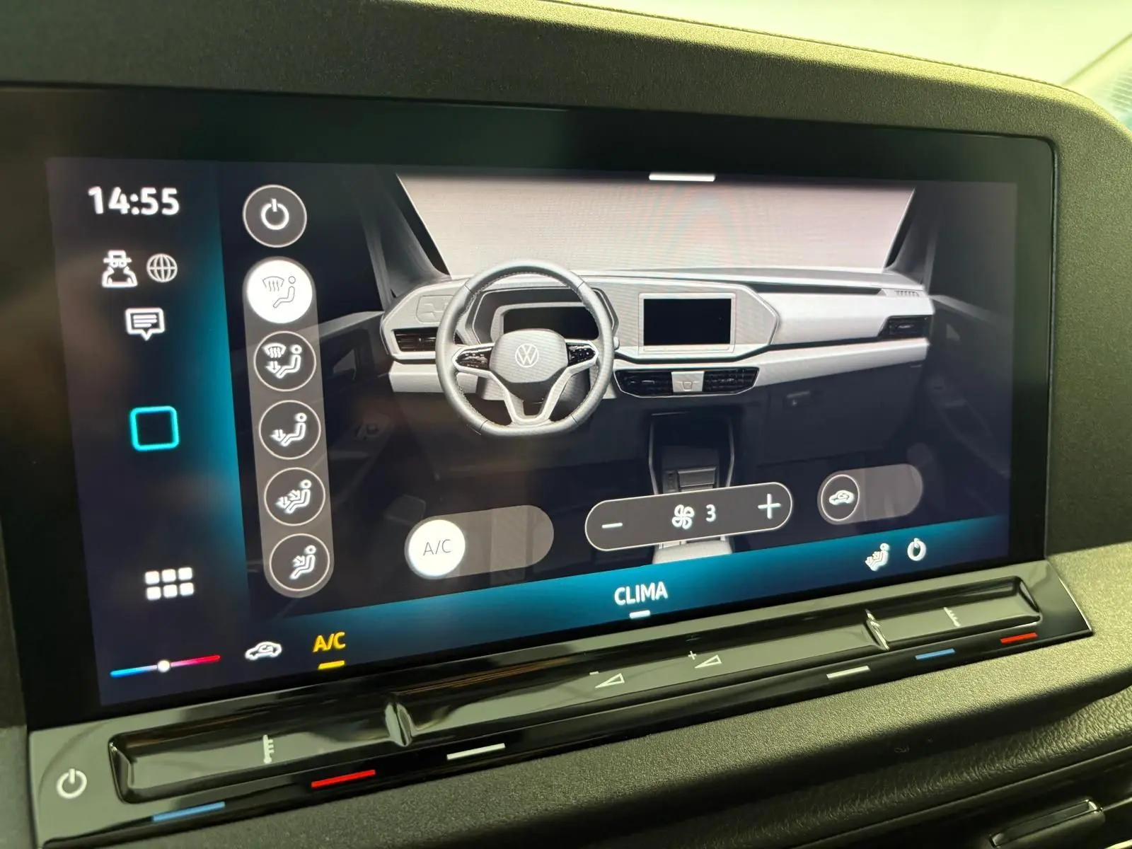 Écran tactile affichant le tableau de bord numérique du Volkswagen Caddy 2025 avec commandes climatisation et volant visible.