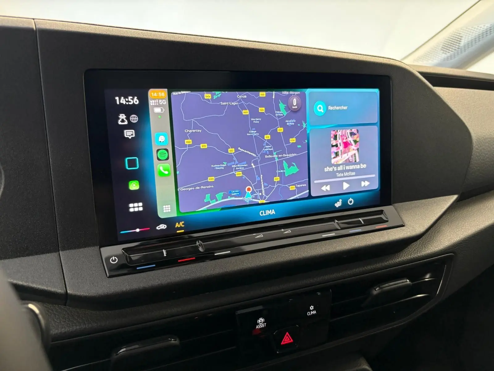 Écran tactile central du tableau de bord du Volkswagen Caddy 2025 gris argent, affichant la navigation et la musique.