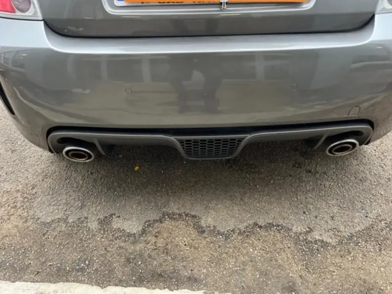 Gros plan sur la double sortie d’échappement chromée arrière d’une ABARTH 500 gris foncé métal de 2013.