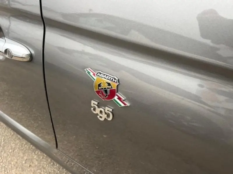 Gros plan sur l'écusson Abarth 595 sur la porte côté gauche d'une ABARTH 500 gris foncé métallisé