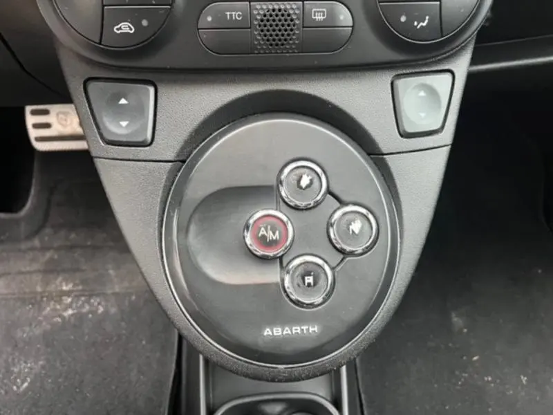 Gros plan sur la commande de boîte automatique noire avec logo Abarth dans l’habitacle d’une ABARTH 500 gris foncé métal.