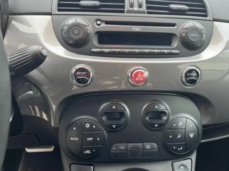 Tableau de bord gris foncé de l'Abarth 500 2013 avec commandes sport, climatisation automatique et système audio intégré.