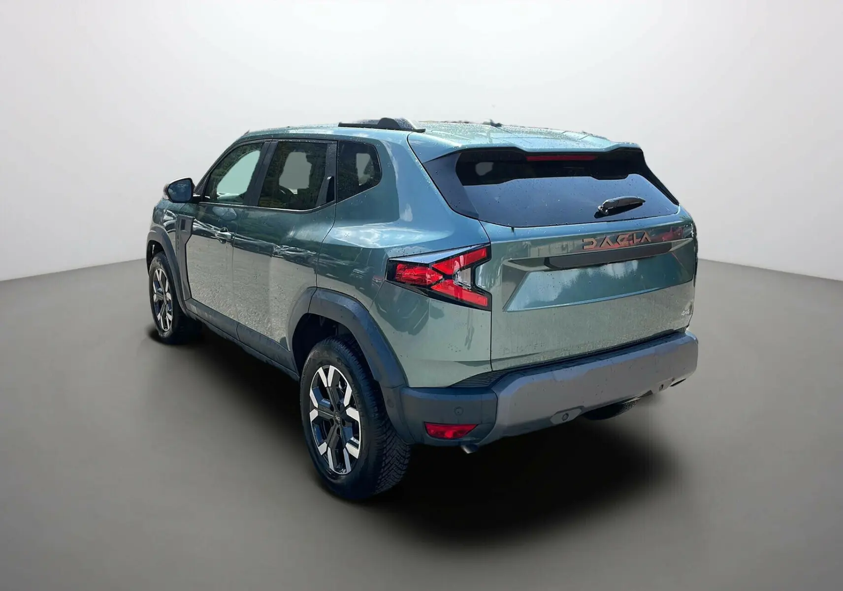 Dacia Duster 2025 vert cèdre en 3/4 arrière droit, avec jantes alliage et logo DACIA sur le hayon.