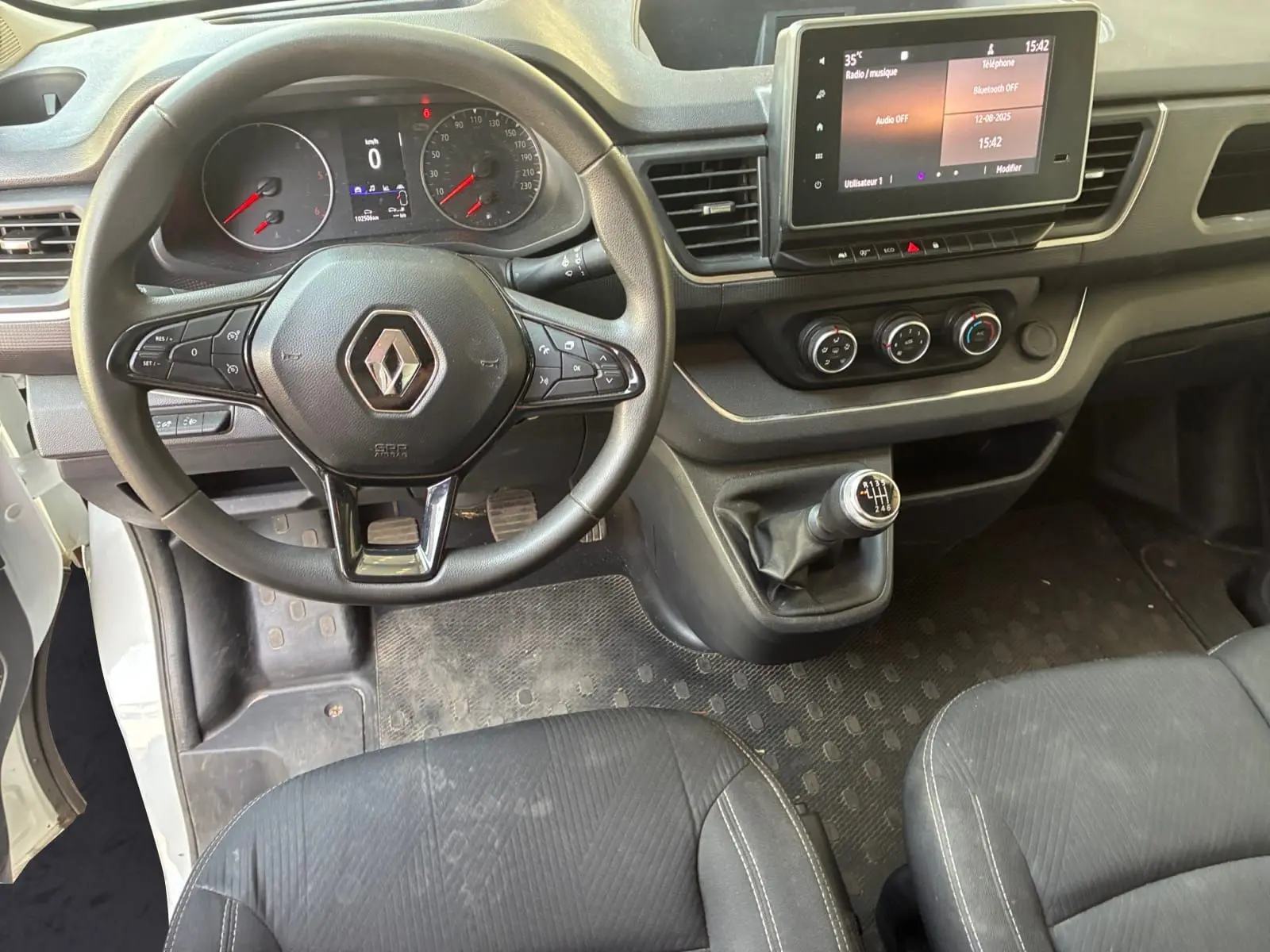 Vue intérieure du tableau de bord du Renault Trafic Fourgon blanc 2022, volant multifonctions et écran tactile 8 pouces.