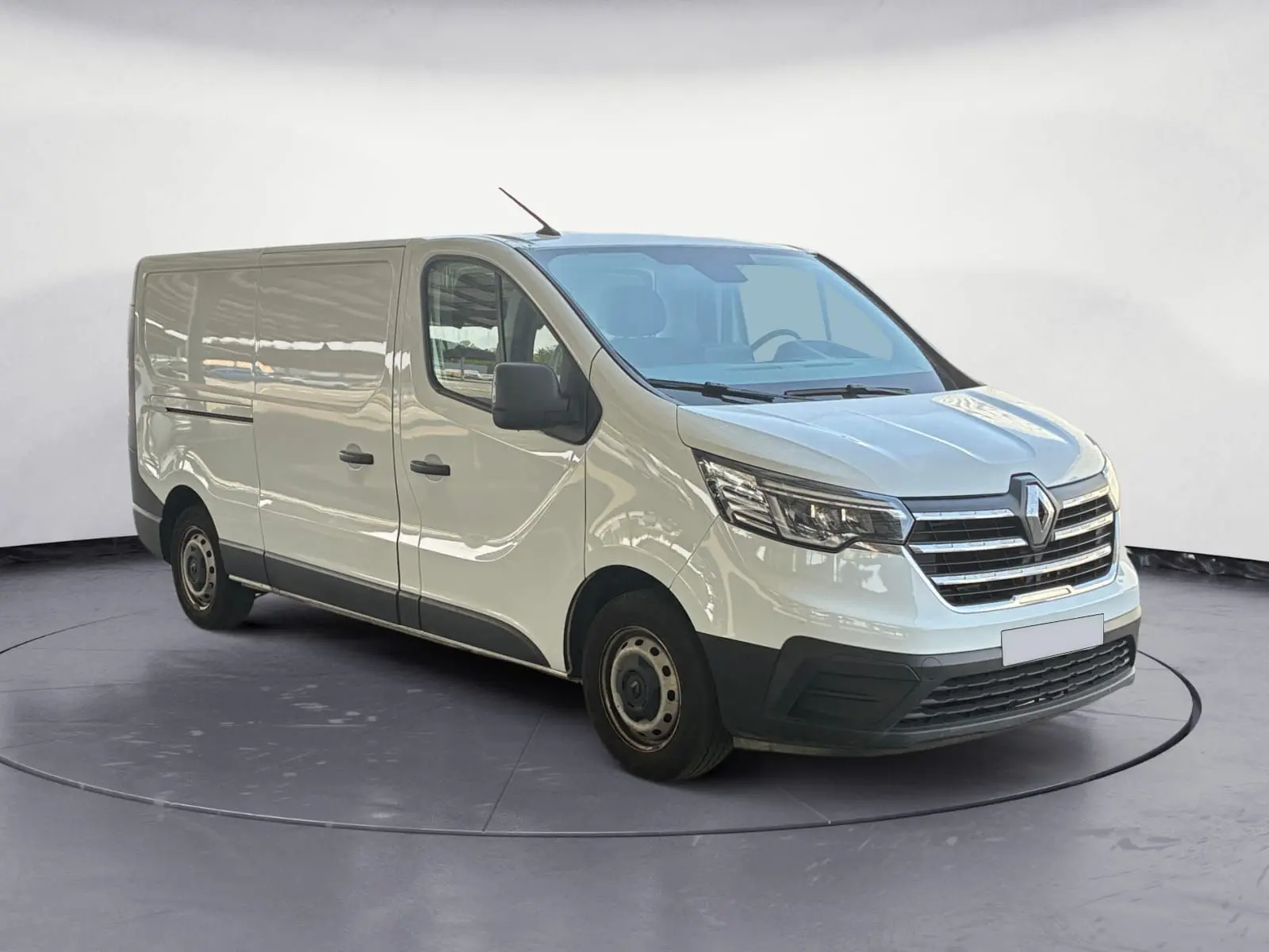 Renault Trafic Fourgon blanc en 3/4 avant droit, avec calandre chromée et jantes acier noires.