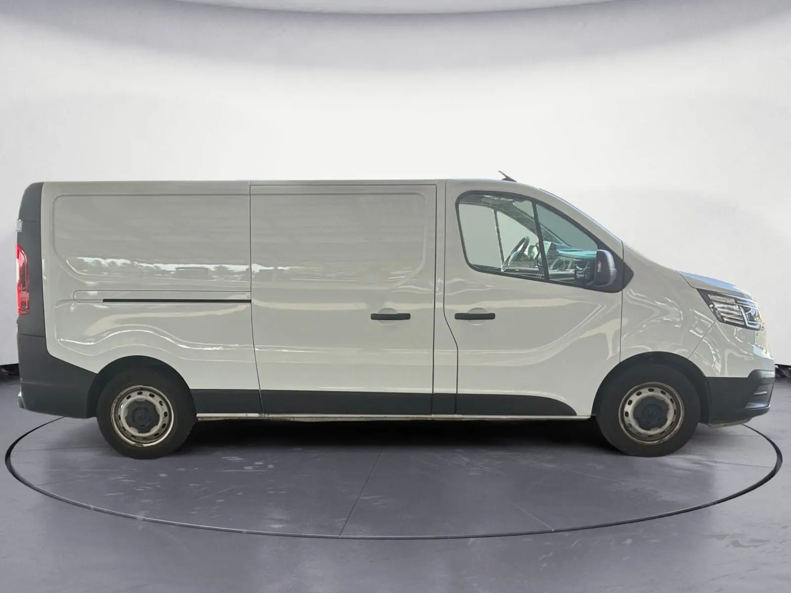 Profil côté droit d'un utilitaire Renault Trafic Fourgon blanc, version L2H1 3T, avec portes coulissantes et jantes acier.