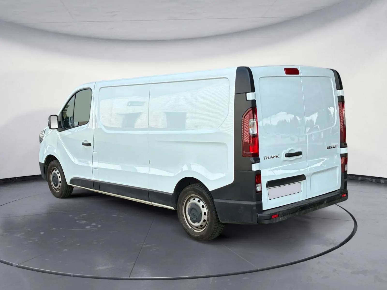 Vue 3/4 arrière droit d'un Renault Trafic Fourgon blanc L2H1 avec portes arrière fermées dans un studio.