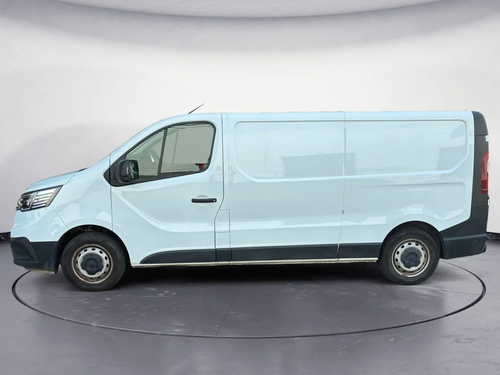 Profil côté gauche d'un fourgon blanc Renault Trafic L2H1 2022 avec jantes acier et pare-chocs noirs.