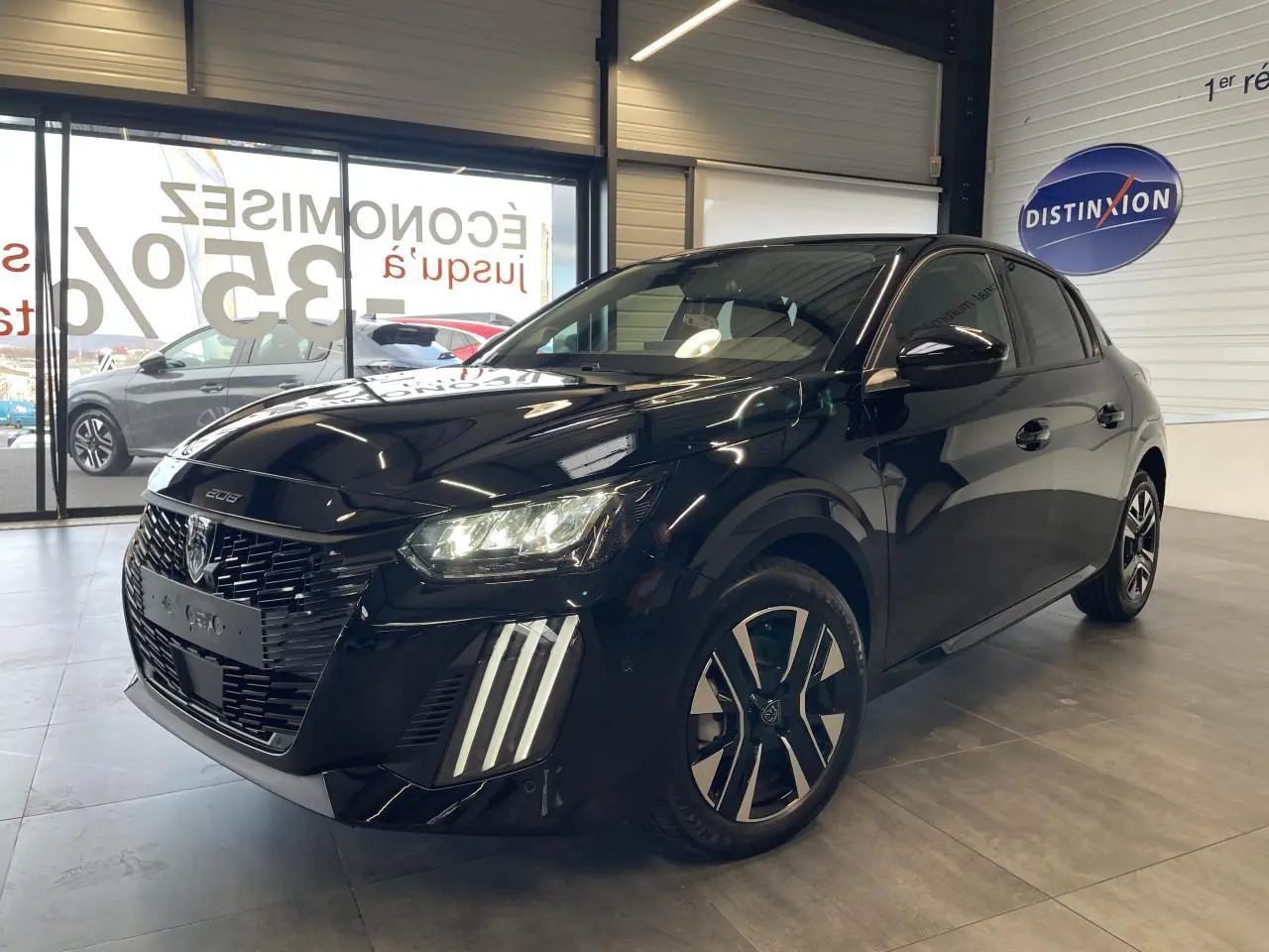 Peugeot 208 noire vue 3/4 avant droit, avec calandre noire grainée et feux LED à griffes distinctifs.
