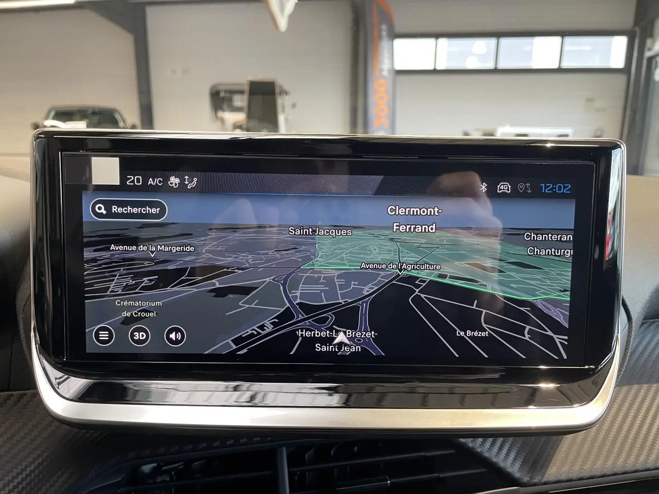 Écran tactile central du tableau de bord Peugeot 208 2025 affichant la navigation GPS en intérieur véhicule.