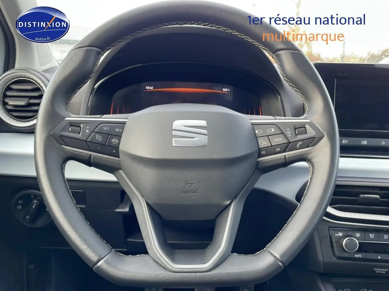 Vue rapprochée du volant cuir noir multifonction de la SEAT Ibiza 2025 avec tableau de bord digital en arrière-plan.