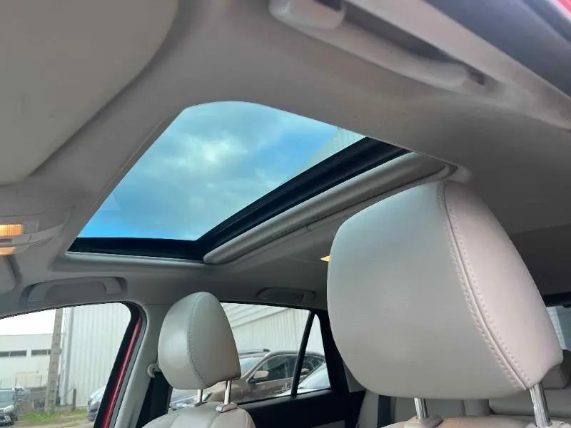 Vue intérieure du toit ouvrant électrique du Mazda CX-5 Soul Red Métallisé, avec appuie-têtes cuir clair en premier plan.