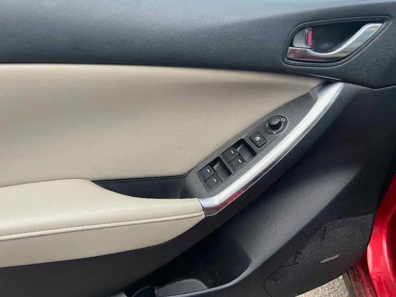 Vue intérieure côté gauche de la porte avant d’un Mazda CX-5 2013, garniture beige et noire avec commandes électriques.