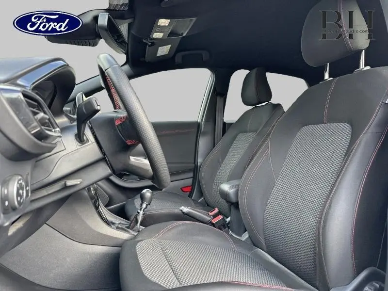 Vue intérieure côté conducteur du Ford Puma 2020, sièges sport noirs avec surpiqûres rouges et volant cuir multifonction.